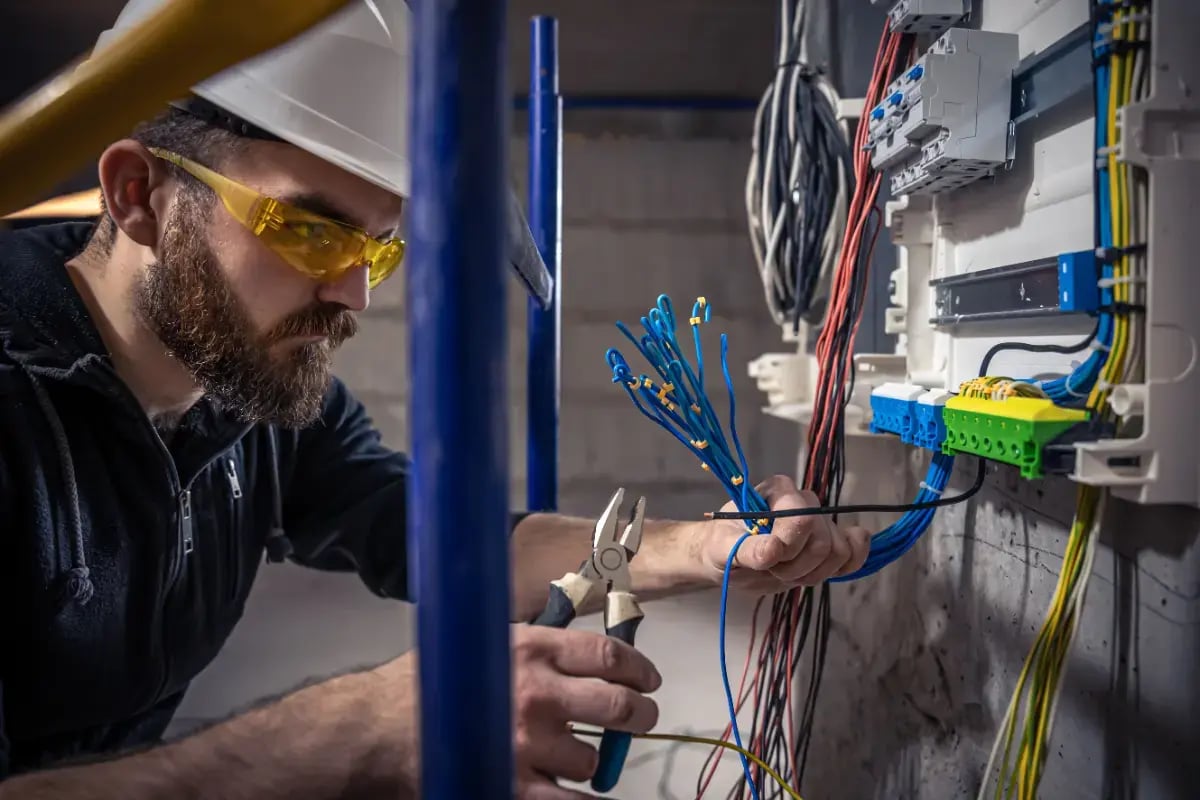 dbc-male-electrician-works-switchboard-with-electrical-connecting-cable (1)